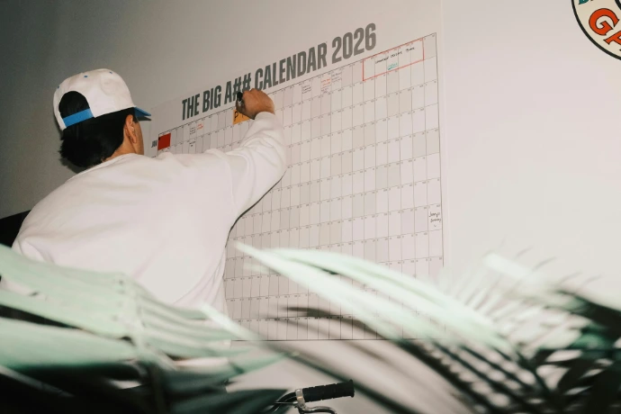 Man writing on a large 2026 calendar